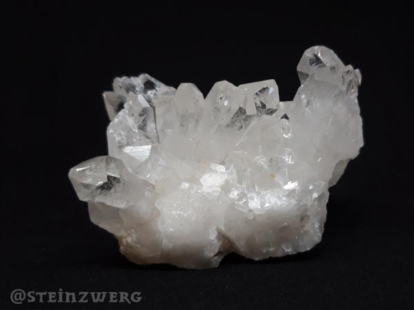 Natürlich gewachsene Bergkristallstufe mit schönen glasklaren Kristallen.